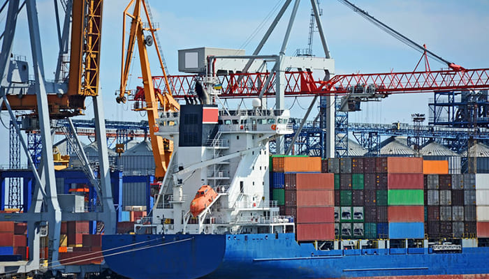 cargo ship in the process of taking in cargo containers in a port