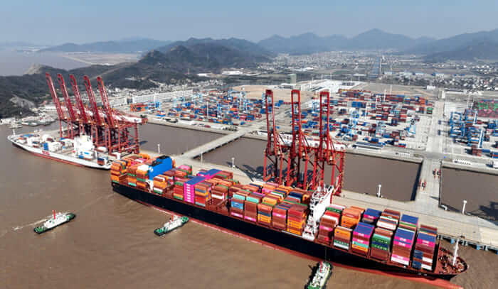 Zhejiang port in China showing a large cargo ship loaded with containers