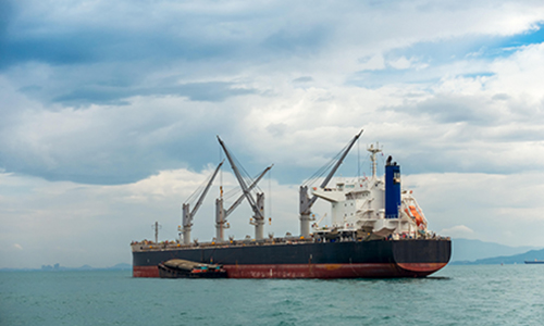 cargo vessel assisted with a smaller boat ready to sail