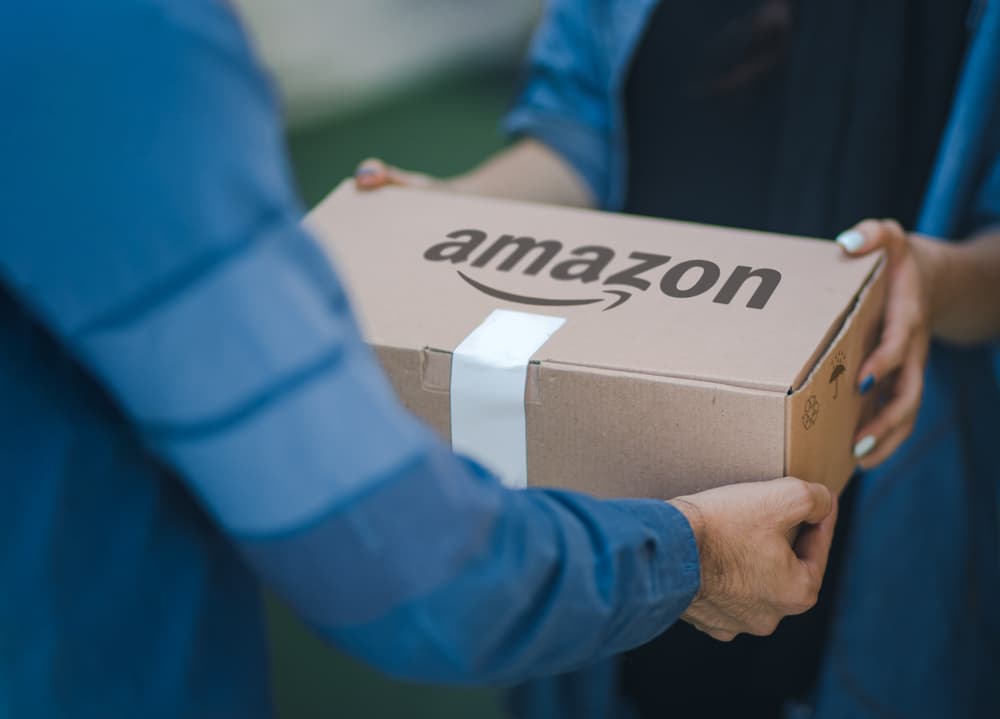 delivery personnel handing an amazon package to recepient