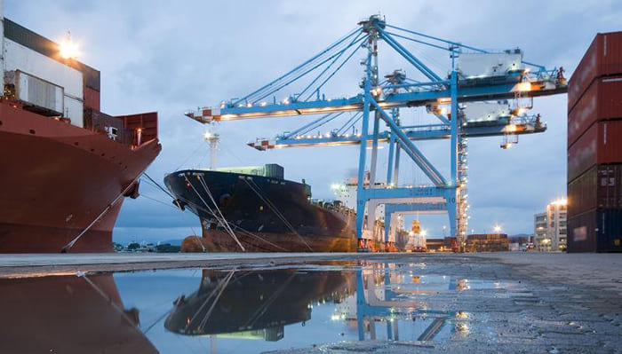 seaport container yard with a crane loading a cargo ship