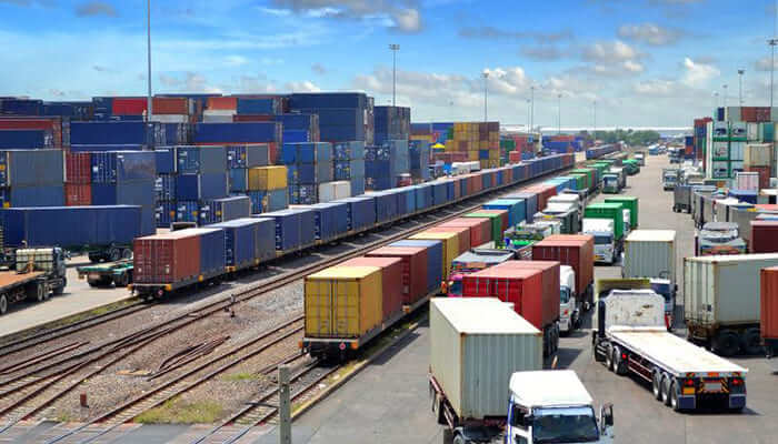 busy train container yard with trains and cars moving to and fro