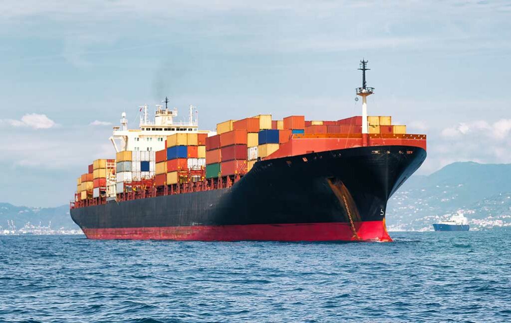 black and orange cargo ship leaving the port