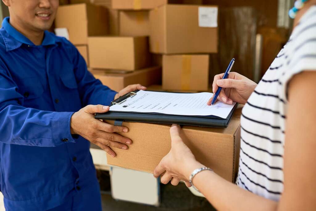 man handing over a package to a lady, lady signing document