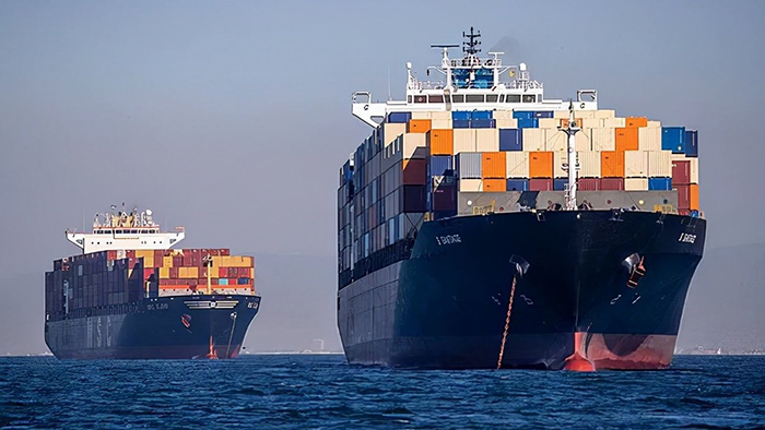 a fleet ships filled with cargo sailing at the open sea