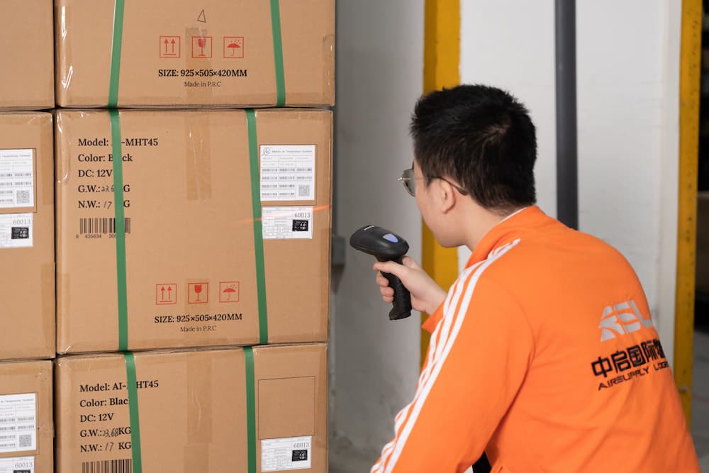 man scanning a label on a packed cardboard box