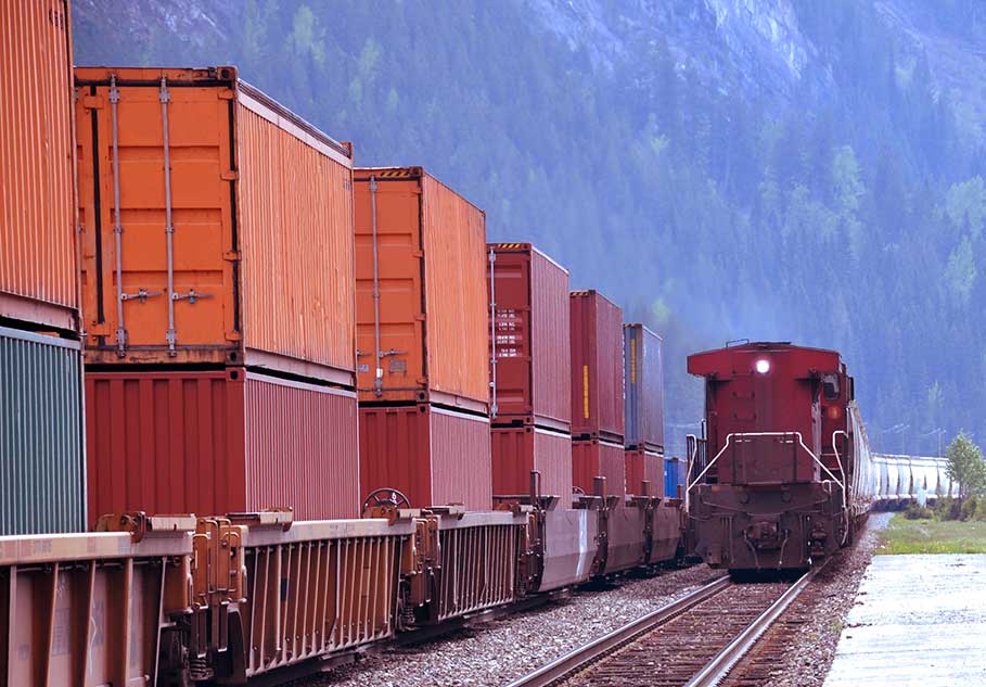 red railroad train with several storage containers at the side