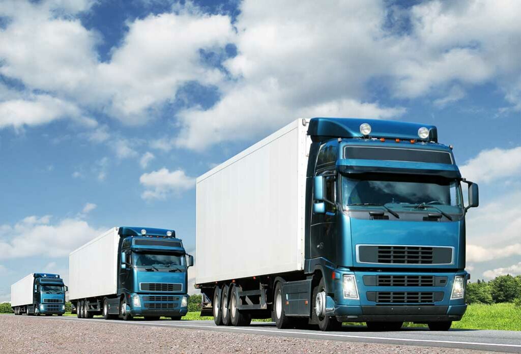 two delivery trucks driving on the road