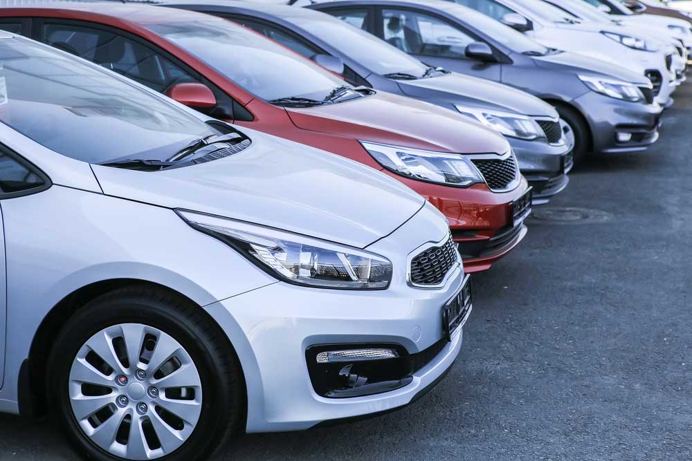 several cars in different colors lined up on a garage