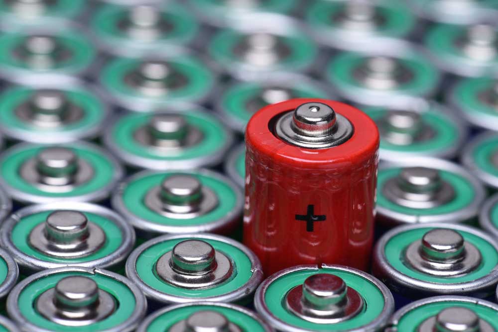 red battery surrounded by regular batteries