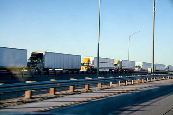 three trucks moving consecutively on a street