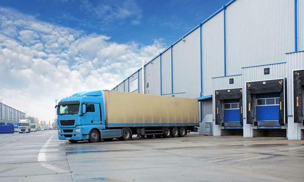 blue delivery truck leaving warehouse with cargo